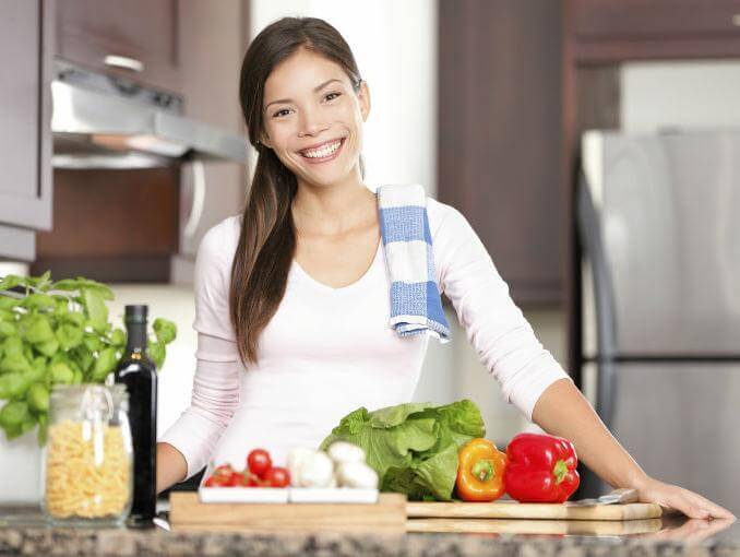 kvinne på kjøkkenet med grønnsaker
