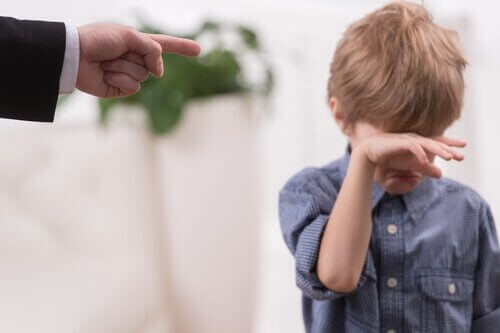 Gutt gråter mens faren peker med en finger