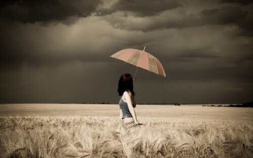 kvinne paraply stormfull åker