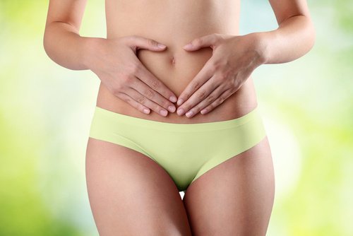 En kvinne som holder seg på magen.