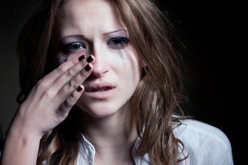 kvinne tørker tårer