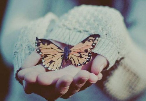 kvinne-med-sommerfugl-i-hånden