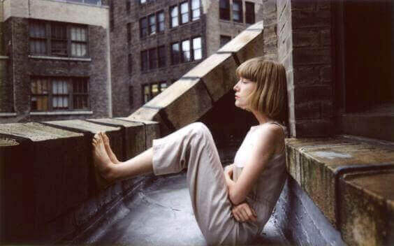 Kvinne sitter på tak-terrasse
