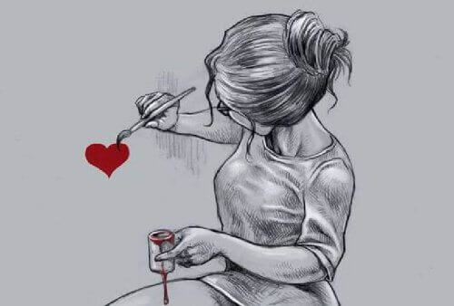 Kvinne tegner hjerte på veggen