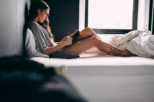 Kvinne leser i sengen
