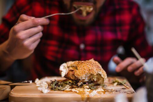 Mann spiser hamburger