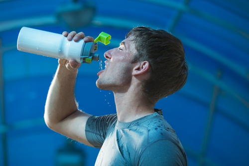 mann drikker vann under trening