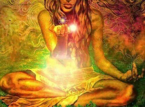 Kvinne mediterer og holder et lys