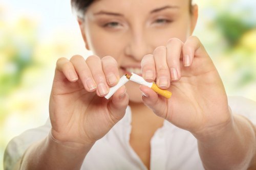 kvinne brekker en sigarett i to