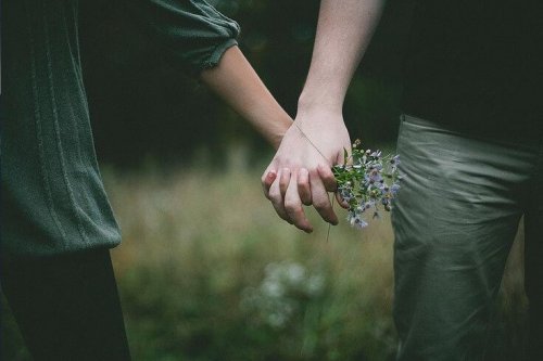 par holder hender og blomster