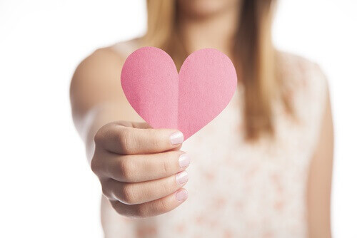 Kvinne holder rosa papirhjerte
