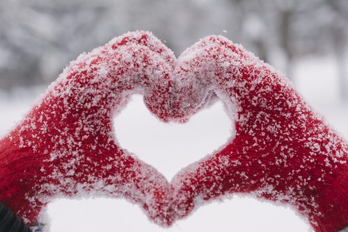 Votter med snø former hjerte