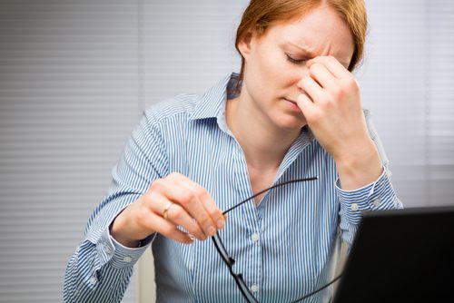 Kvinne på jobb med hodepine