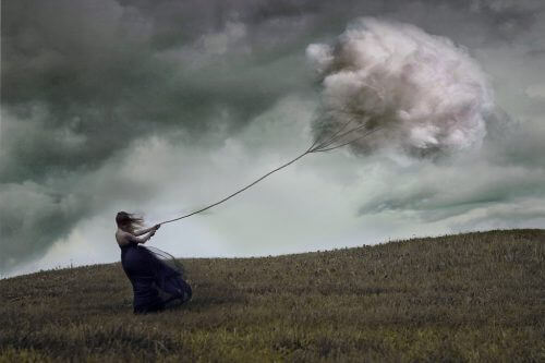 Kvinne holder fast i tau med sky