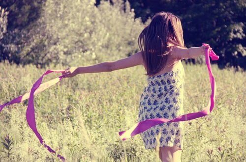 Liten jente løper ute med rosa bånd