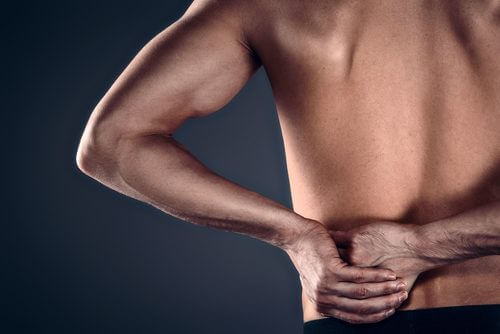 Mann med hendene på ryggen