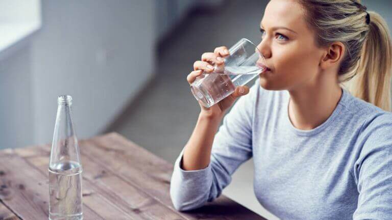 Rehydrering er det viktigste tiltaket, kvinne drikker vann