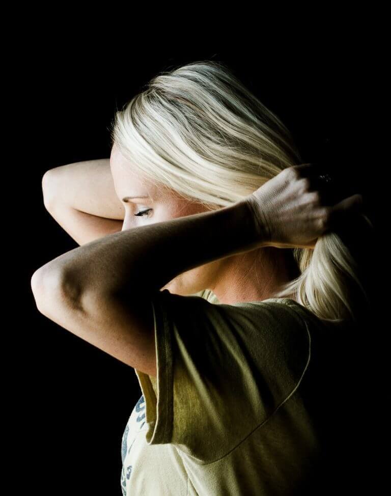 Kvinne løfter håret sitt