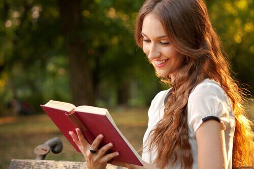Lykkelig kvinne leser bok alene