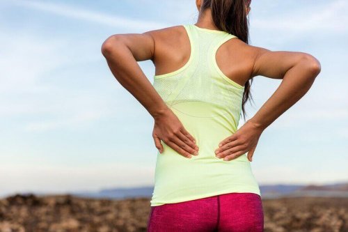 Kvinne med treningsklær har ryggsmerter