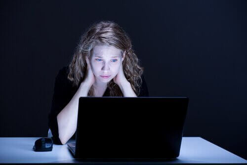 Trist kvinne ser på PC-skjerm