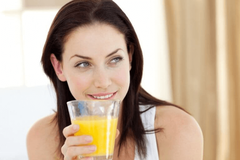 Kvinne drikker ananasjuice