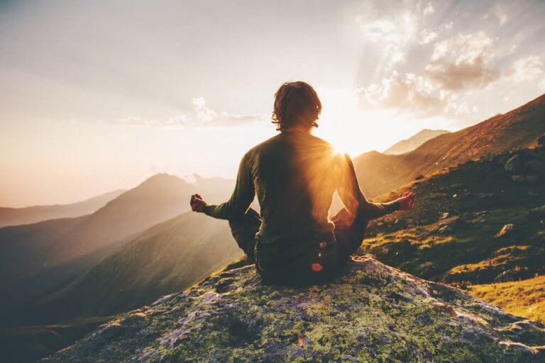 Person mediterer på et fjell