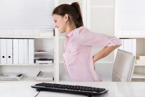 Kvinne på arbeid med ryggsmerter