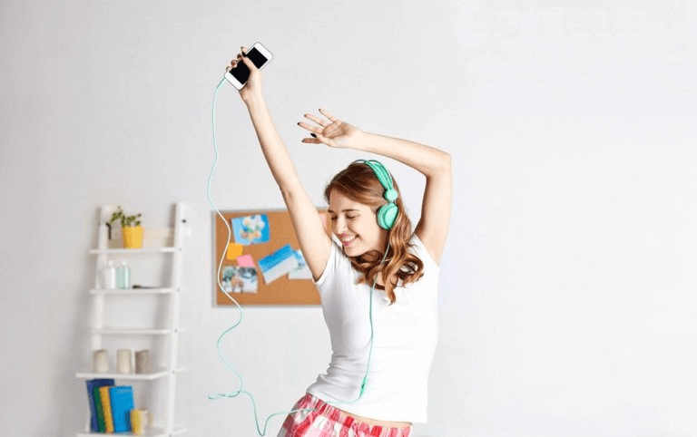 Jente danser og lytter til musikk