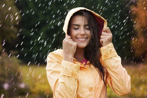 Glad kvinne i regnet