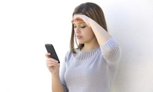 Bekymret kvinne ser på telefonen sin