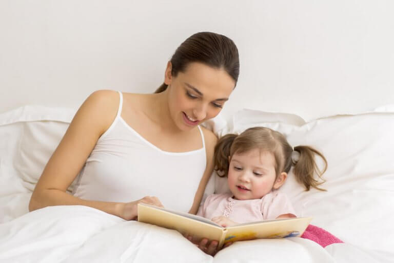 Mor og barn leser i sengen