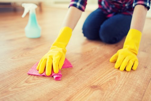 Kvinne prøver å holde huset rent ved å rengjøre gulvet