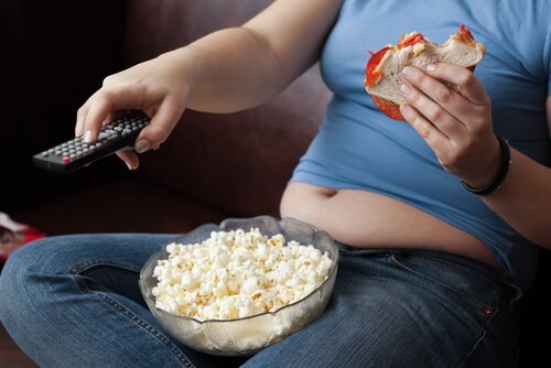 Kvinne spiser popcorn og kommer til å gå opp i vekt