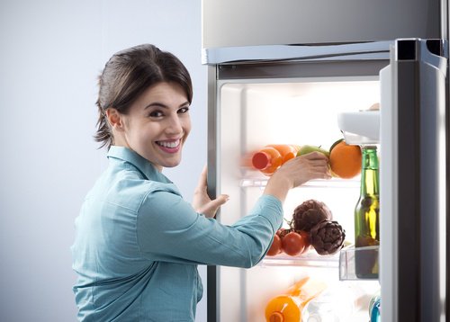 Kvinne oppbevarer mat i kjøleskap