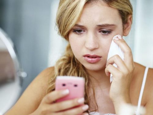 Kvinne gråter ved telefon