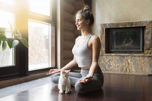 Kvinne mediterer med katt
