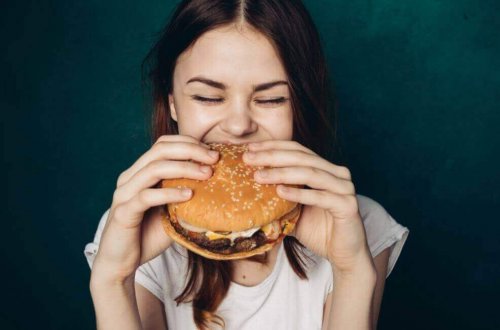 Kvinne spiser hamburger