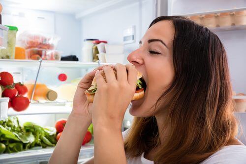 Jente spiser fra kjøleskapet