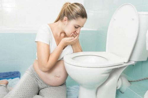 Gravid kvinne som holder på å kaste opp i do