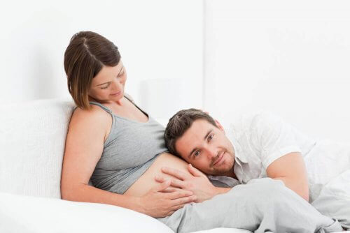 Mann som hører på gravid dames mage