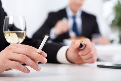 Menn i dress med vin og sigaretter, som er dårlige vaner.