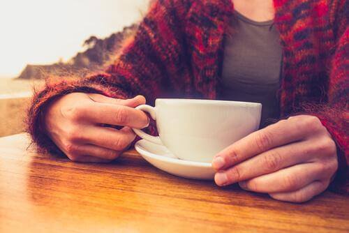 Person med koffeinabstinenser holder kaffekopp