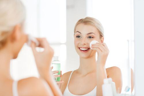 Kvinne påfører toner for å sikre ren og jevn hud