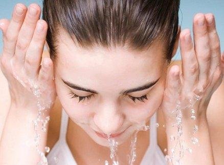 En dame som vasker ansiktet.