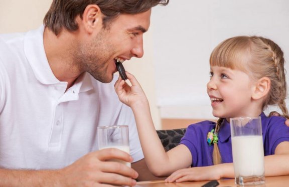 Far og datter spiser sjokolade