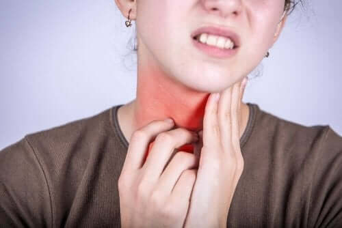 Symptomer på faryngitt: En kvinne med sår hals.