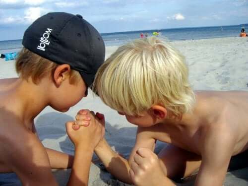 Dra på stranden: To barn utfordrer hverandres styrke.