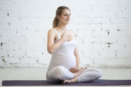 Gravid kvinne praktiserer yoga