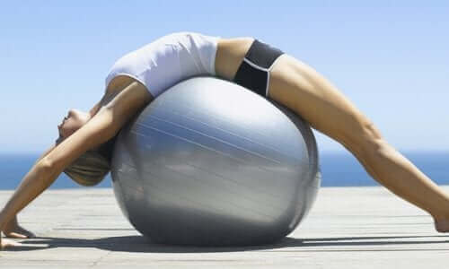 En kvinner som ligger på en pilatesball